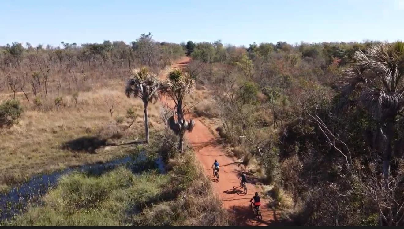 Vista aérea de ciclistas na trilha do Itororó Park Club em meio ao cerrado